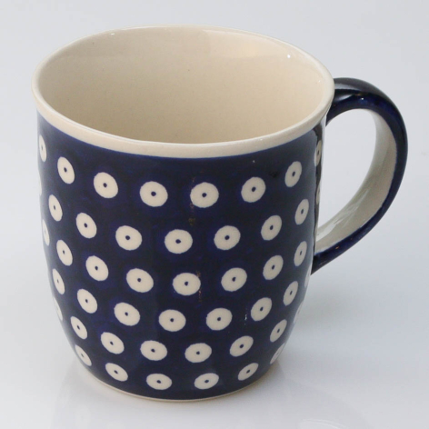 Navy ceramic mug with white polka dot pattern and black handle, front view