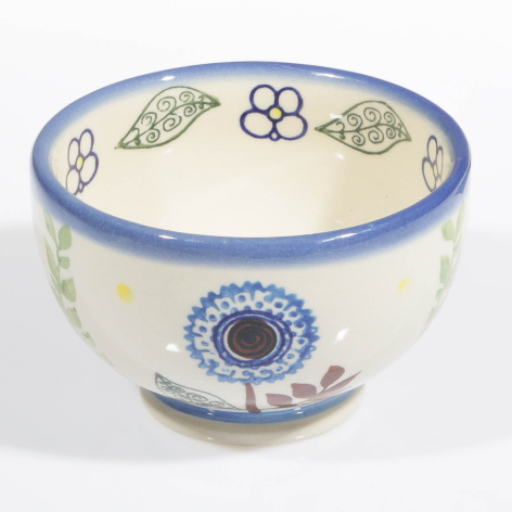 Cream ceramic bowl with blue rim, hand-painted blue and floral motifs around the exterior
