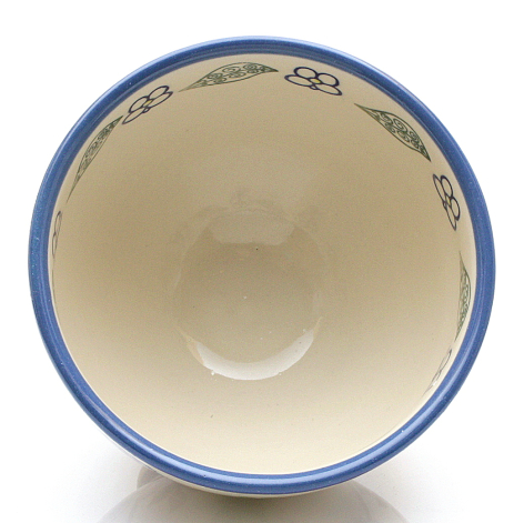 Ceramic bowl with cream interior, blue rim, and decorative blue patterned band, viewed from above