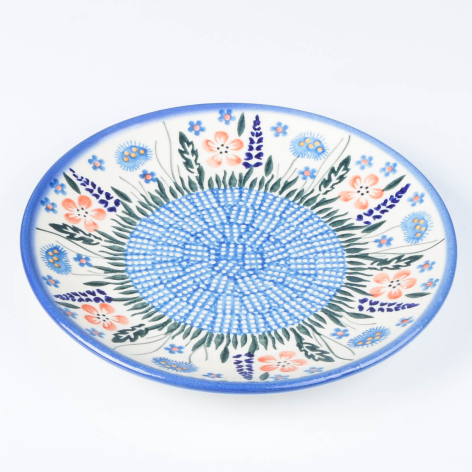Blue and white ceramic bowl with hand-painted radiating patterns and decorative motifs, viewed from above
