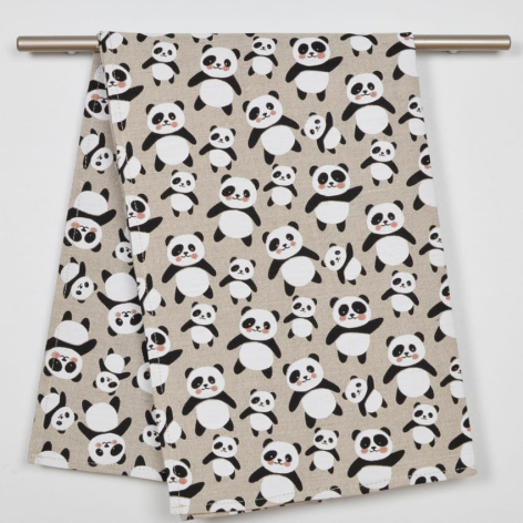 Cream-colored textile with black playful face pattern, draped over metal rod on white background