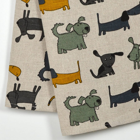 Cream linen textile with scattered pattern of black dachshunds, mustard and green elephants in playful poses