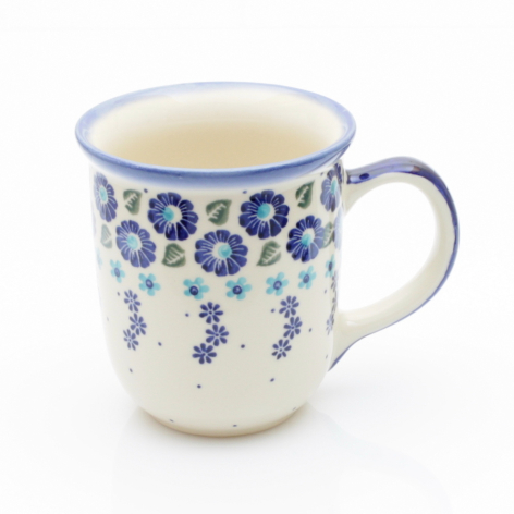 Cream ceramic mug with blue floral pattern and curved handle, three-quarter front view