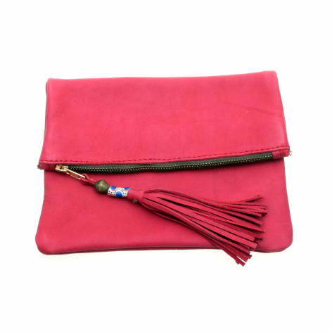 Bright pink fold-over clutch with black leather strap and decorative tassel detail, front view