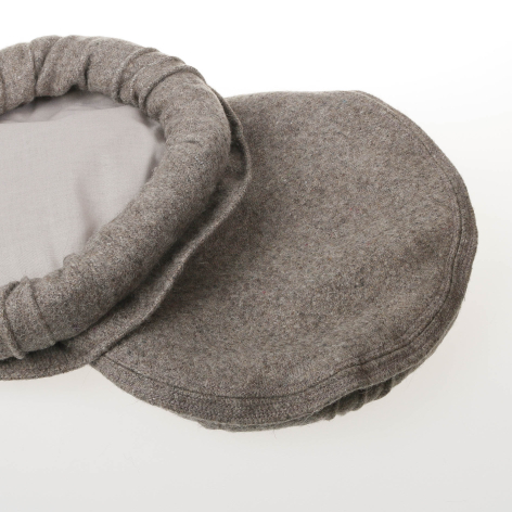 Grey linen neck pillow with gathered fabric edge and curved ergonomic shape, angled view showing texture detail