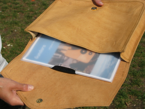 Sac en cuir camel ouvert révélant un compartiment intérieur bleu, vue de détail du rabat et de l'organisation interne