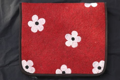 Red textile with white floral pattern, folded flat view showing repeating flower motifs across surface