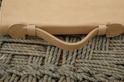Wooden hair brush with natural bristles on neutral woven textile, top view with curved handle and dense bristles
