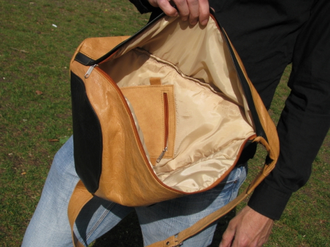 Sac à dos en cuir caramel ouvert montrant l'intérieur beige clair, vue de face avec doublure visible