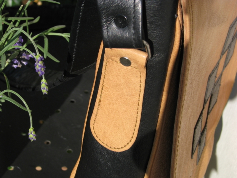 Porte-clés en cuir caramel avec détail de couture contrastante, vue de face sur fond noir
