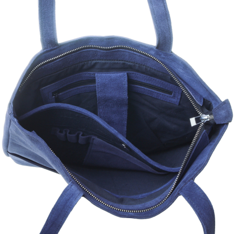 Open blue leather tote bag showing interior compartments and navy fabric lining, top view