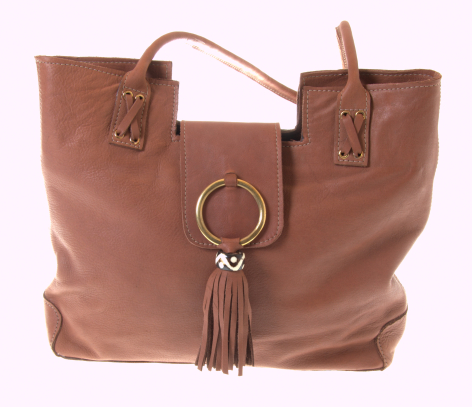 Tan leather tote bag with dual handles and decorative tassel charm, front view
