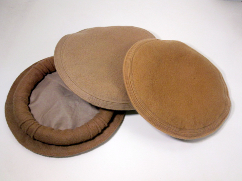 Tan and brown fabric coasters stacked and overlapping, showing woven textile detail from above