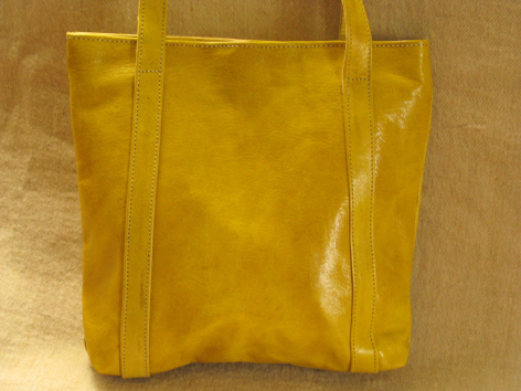Sac à main artisanal en cuir jaune doré, vue de face, avec anses renforcées et finitions cousues visibles
