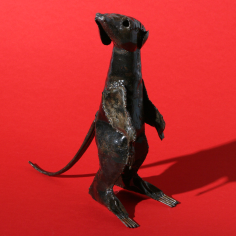 Black leather dog figurine standing upright against red background, handcrafted with detailed stitching