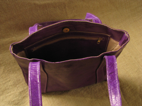 Dark brown leather tote bag with purple handles, open view showing empty interior