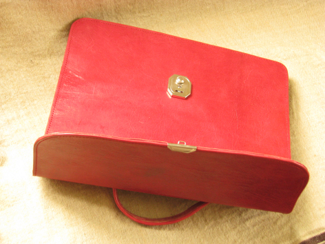 Red and brown leather wallet with gold clasp detail, front view showing structured rectangular shape