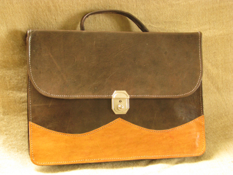 Serviette en cuir marron et orange avec rabat arrondi et fermoir métallique argenté, vue de face