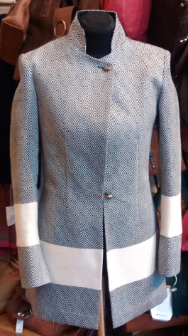 Light grey wool sleeveless vest displayed on dress form, front view showing button closure and layered hem detail