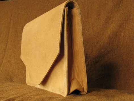 Tan leather shoulder bag with structured rectangular shape and curved flap closure, front view