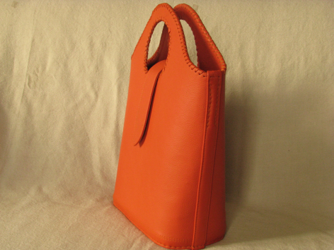 Orangefarbene Ledertasche mit zwei Griffen, Frontansicht auf neutralem Hintergrund