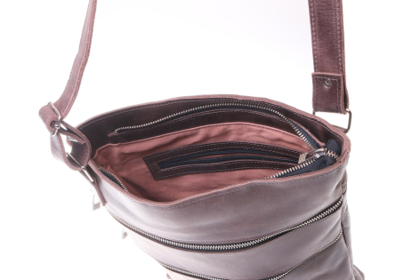 Braune Ledertasche, geöffnet, zeigt rosa Innenfutter und Schultergurt aus Leder, Detailansicht des Verschlusses