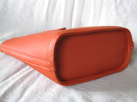 Sac à main en cuir orange rouille, vue de dessus montrant la forme structurée et les poignées