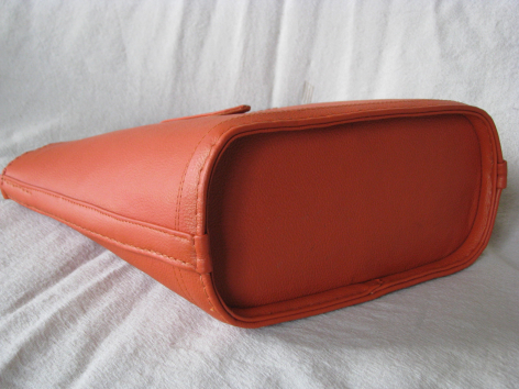 Rust-red leather shoulder bag with rounded top and structured rectangular base, front view