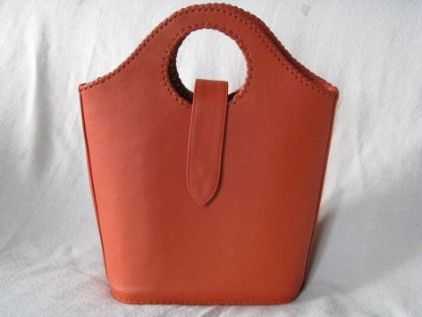 Terrakottafarbene Ledertasche mit abgerundeter Form und großem rundem Griff, Vorderansicht