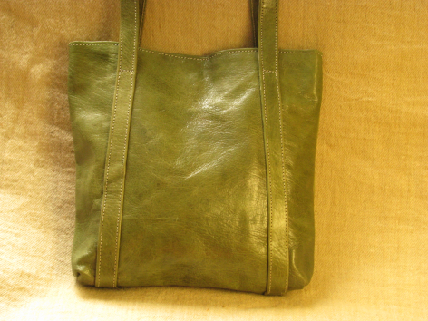 Olive green leather tote bag with structured sides, front view showing weathered patina finish