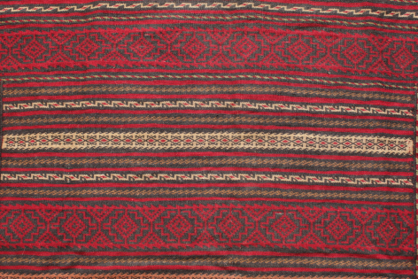 Red textile with horizontal woven stripes in gold and cream, showing traditional patterned weaving detail