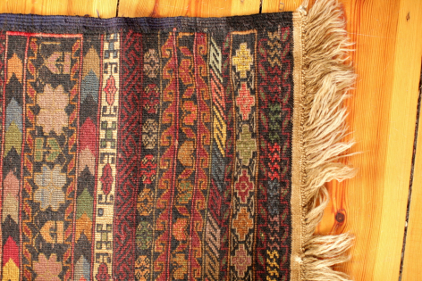 Handwoven textile wall hangings in burgundy, navy and gold with traditional geometric patterns