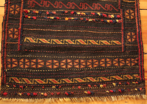 Dark indigo textile with gold and red geometric patterns, woven borders, repeating motifs on golden-yellow background