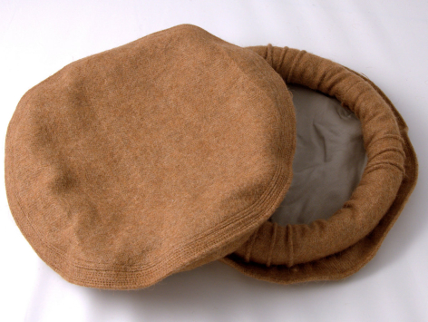 Sac en cuir marron clair vue de dessus avec doublure grise visible, forme arrondie et poignées texturées