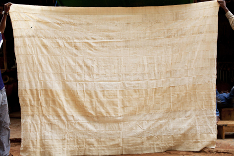 Beige Baumwolltuch mit natürlichen Farbvariationen, hängend an Schnur, handwerklich gefärbt und gewebt