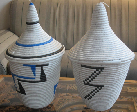 White woven storage baskets with lids, blue and black geometric stripe patterns, front view