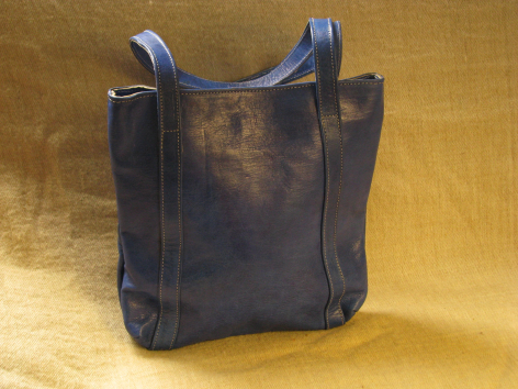 Sac à main en cuir bleu marine vue de face, design carré avec poignées épaisses et patine vieillie
