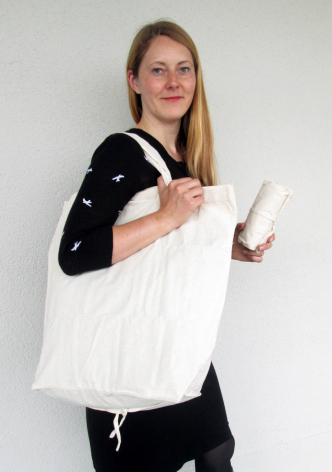 Sac à main blanc en cuir avec poignées, porté par une femme vêtue de noir en vue de face