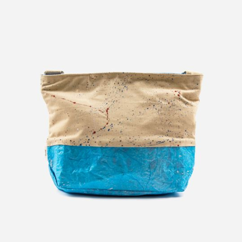 Colorblock textile pouch in natural tan and bright blue with woven texture and raw edges, front view