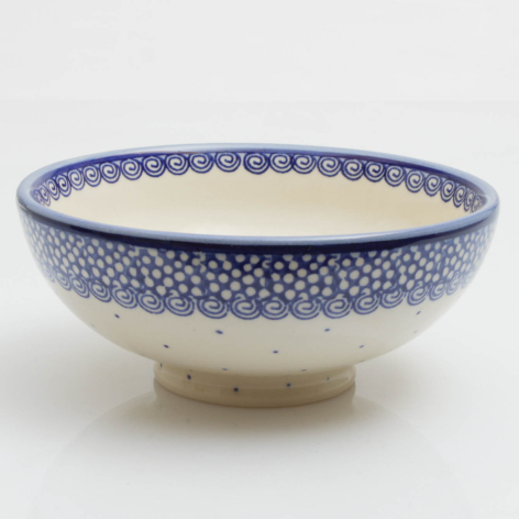 Blue and cream ceramic bowl with intricate dotted pattern, elevated on a small pedestal base, top view