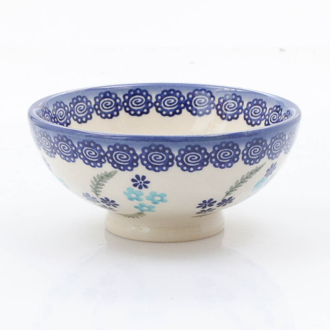 Blue and cream ceramic bowl with decorative rim pattern and painted floral motifs on interior