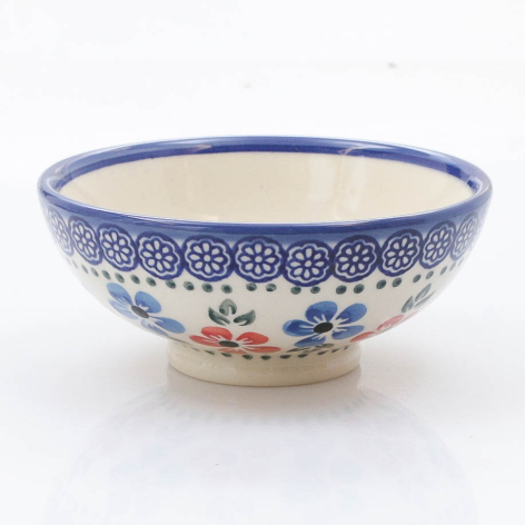 Blue and white ceramic bowl with hand-painted floral design and decorative patterned rim, front view