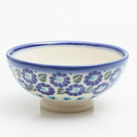 Ceramic bowl with blue floral pattern and natural clay base, front view showing wide shallow shape