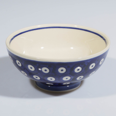 Navy blue ceramic bowl with white floral pattern, cream interior, rounded pedestal base, front three-quarter view