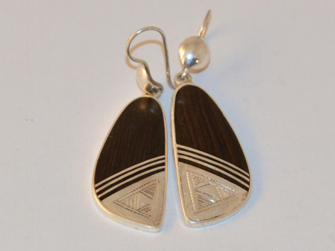 Boucles d'oreilles en métal doré avec pendants géométriques bicolores noir et beige, vue de face