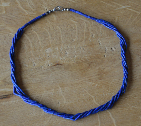 Blaues geflochtenes Armband aus Stoff mit quadratischem Design, Draufsicht auf Holzoberfläche
