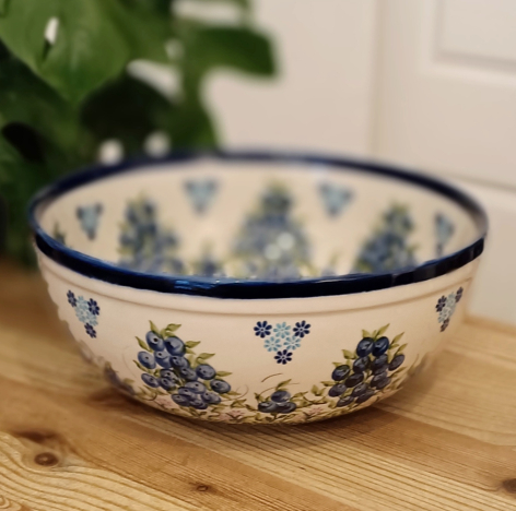 Blue and white ceramic bowl with traditional floral pattern, viewed from above on wooden surface