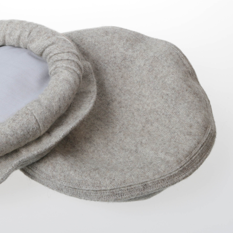 Beige wool ear warmer headband with padded fleece lining, overhead view showing curved shape and soft texture