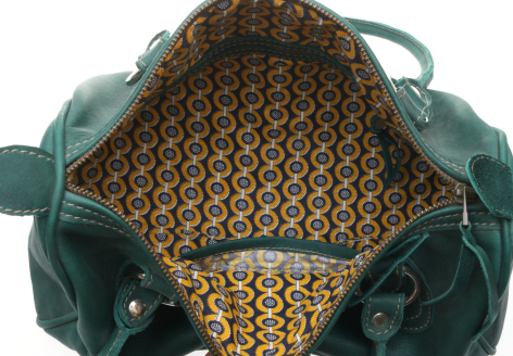 Dark green leather bag open to reveal patterned golden interior lining with handles visible from above