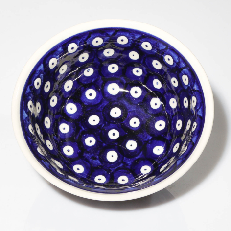 Deep blue ceramic bowl with white polka dot pattern, viewed from above